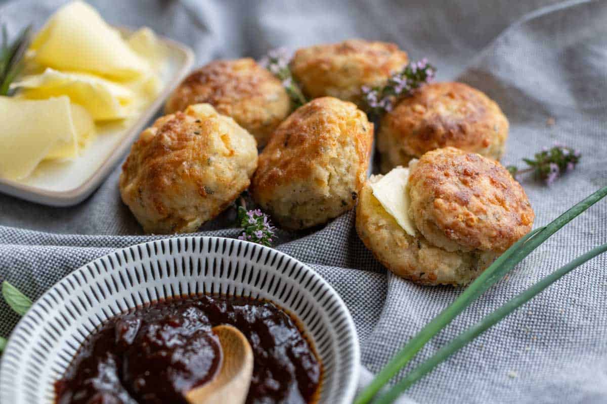 Savoury cheese scones with chutney and butter in dishes. 