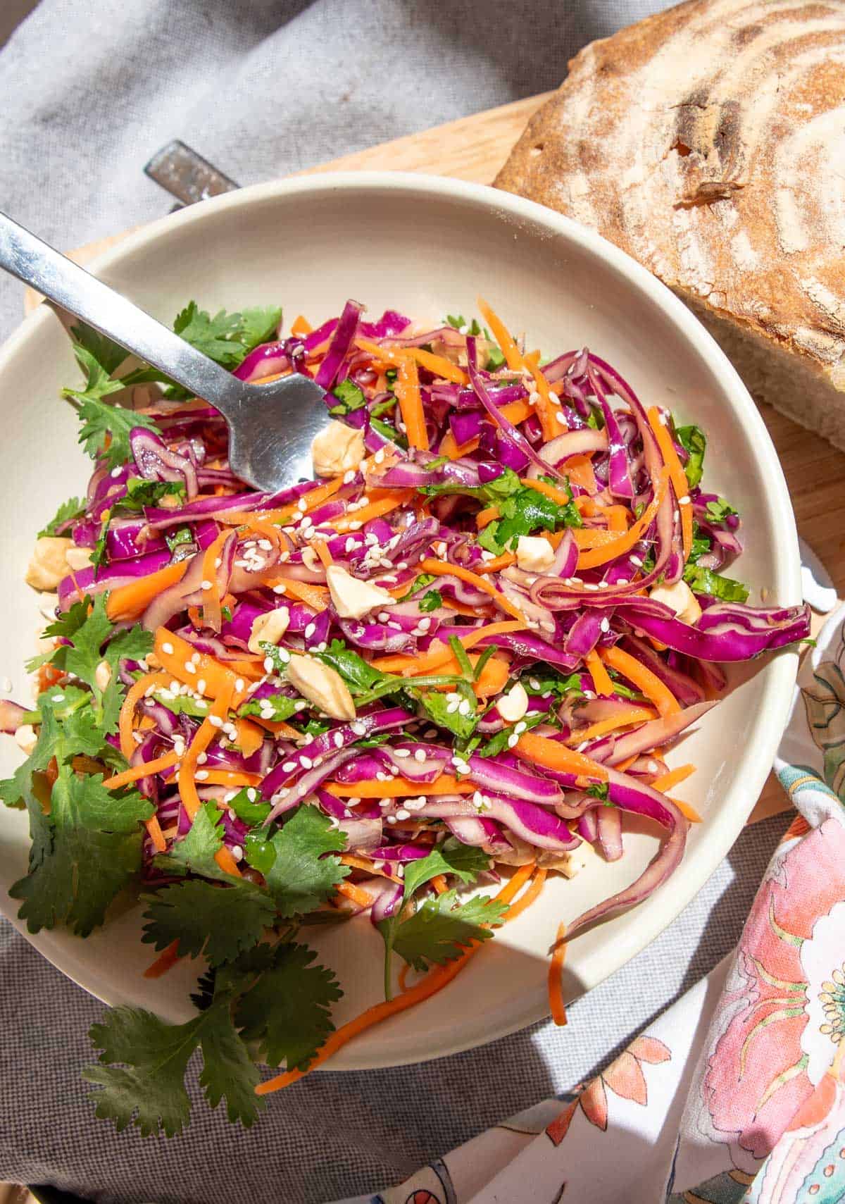 Asian coleslaw with fresh bread at a picnic.