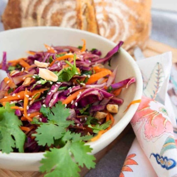 Asian coleslaw with fresh bread at a picnic.