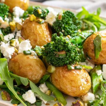 A plate with potato and broccoli salad topped with feta.