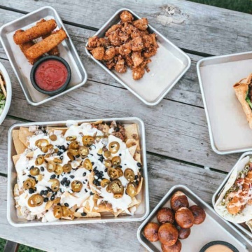Assorted hot food laid out on a picnic table.