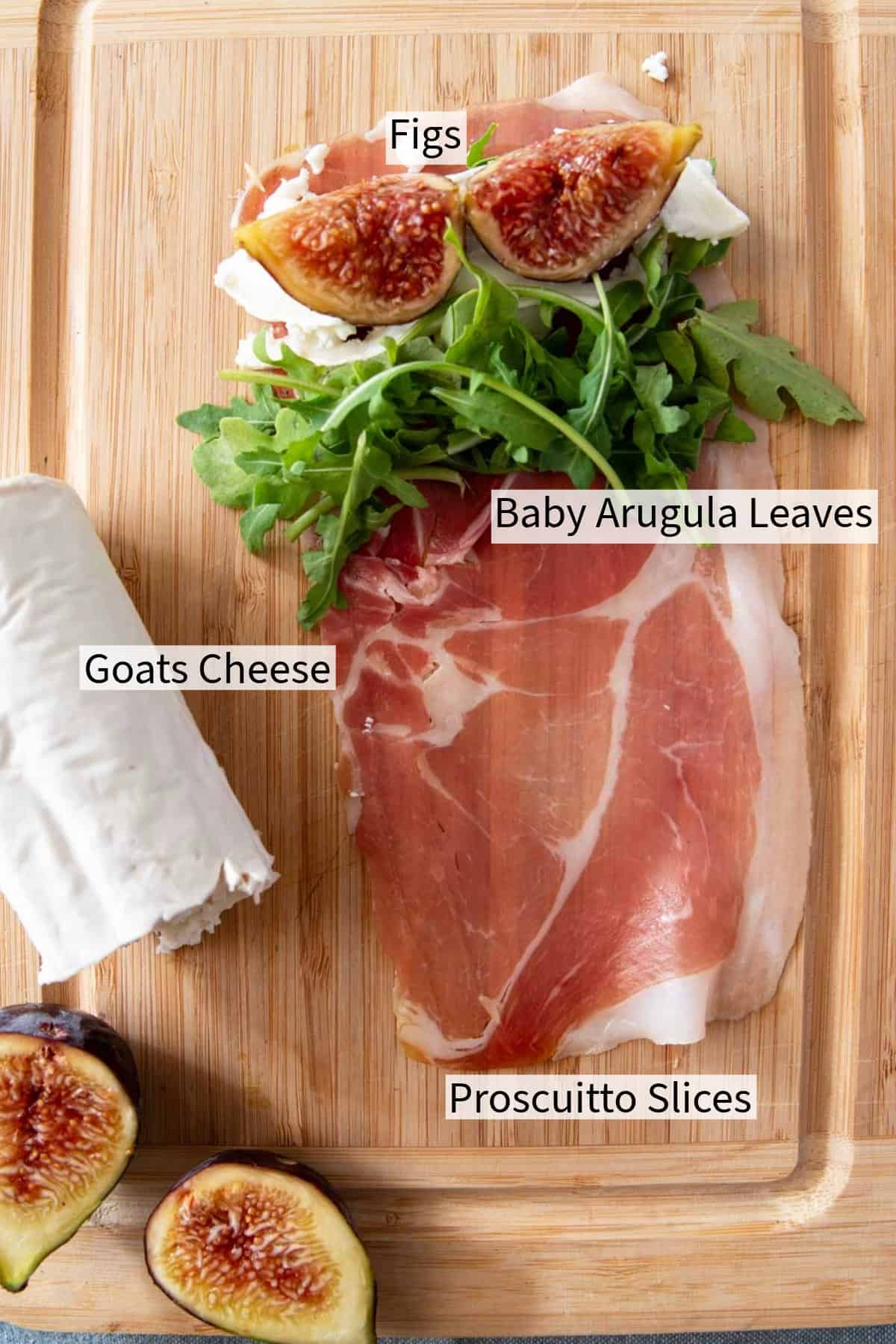Figs, prosciutto, goat cheese and figs on a cutting board.
