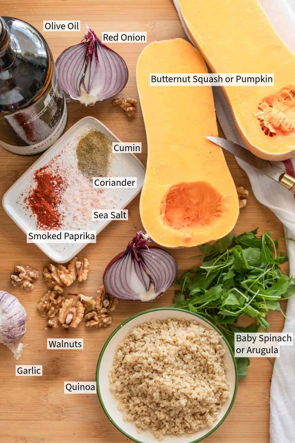 Top view of a cutting board with labeled ingredients for a pumkpin salad recipe.