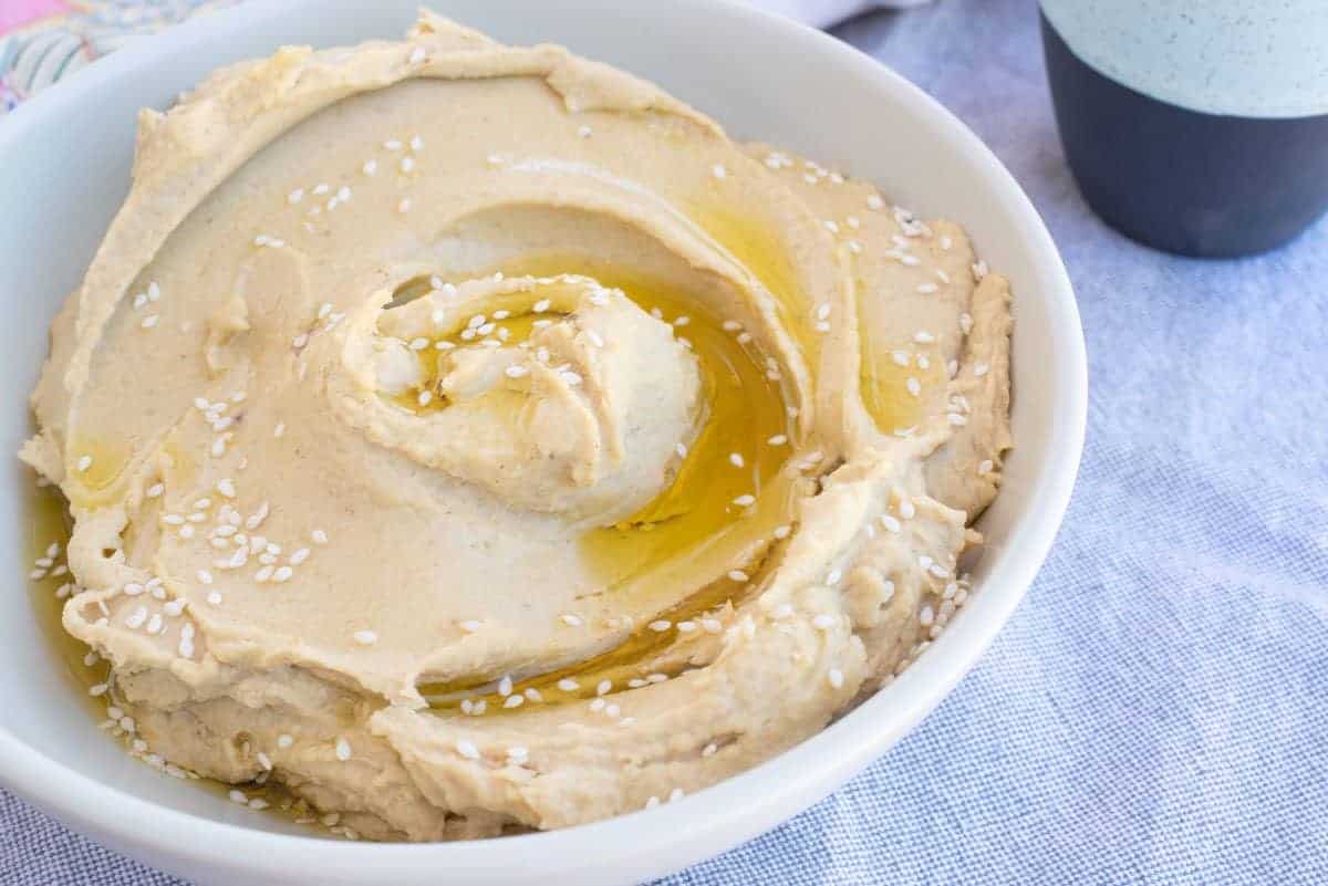 Bowl of hummus topped with sesame seeds. 