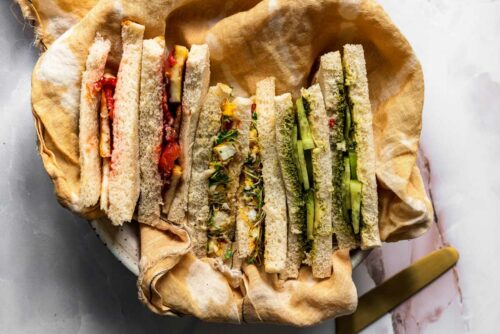 Indian style tea sandwiches in a basket with a cloth napkin.