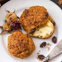 pumpkin and raisin scones with butter on a plate.