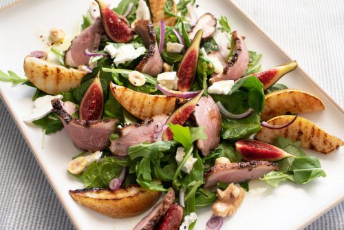 Plate of colourful smoked duck and grilled pear salad.