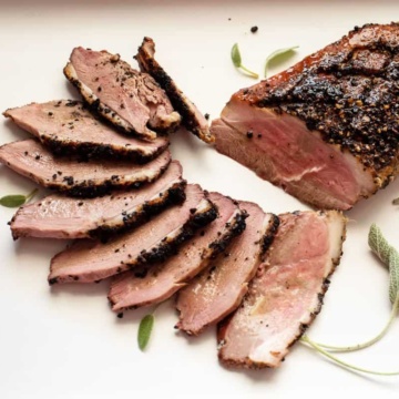 Smoked duck breast with thin slices fanned on a plate.