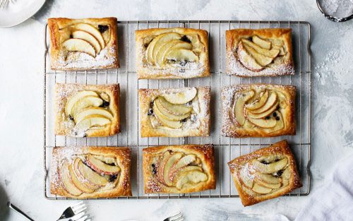 Apple tarts on a baking tray dusted with sugar. A perfectly portable picnic dessert.