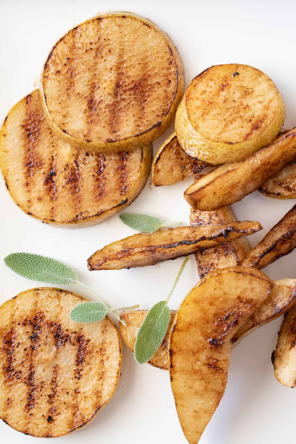 A plate of grilled pears and a leafy plant.
