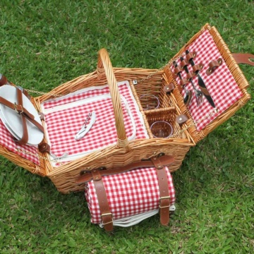 Picnic basket with red check lining on green grass