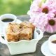 Sweet zucchini bread in a picnic scene with coffee and flowers.