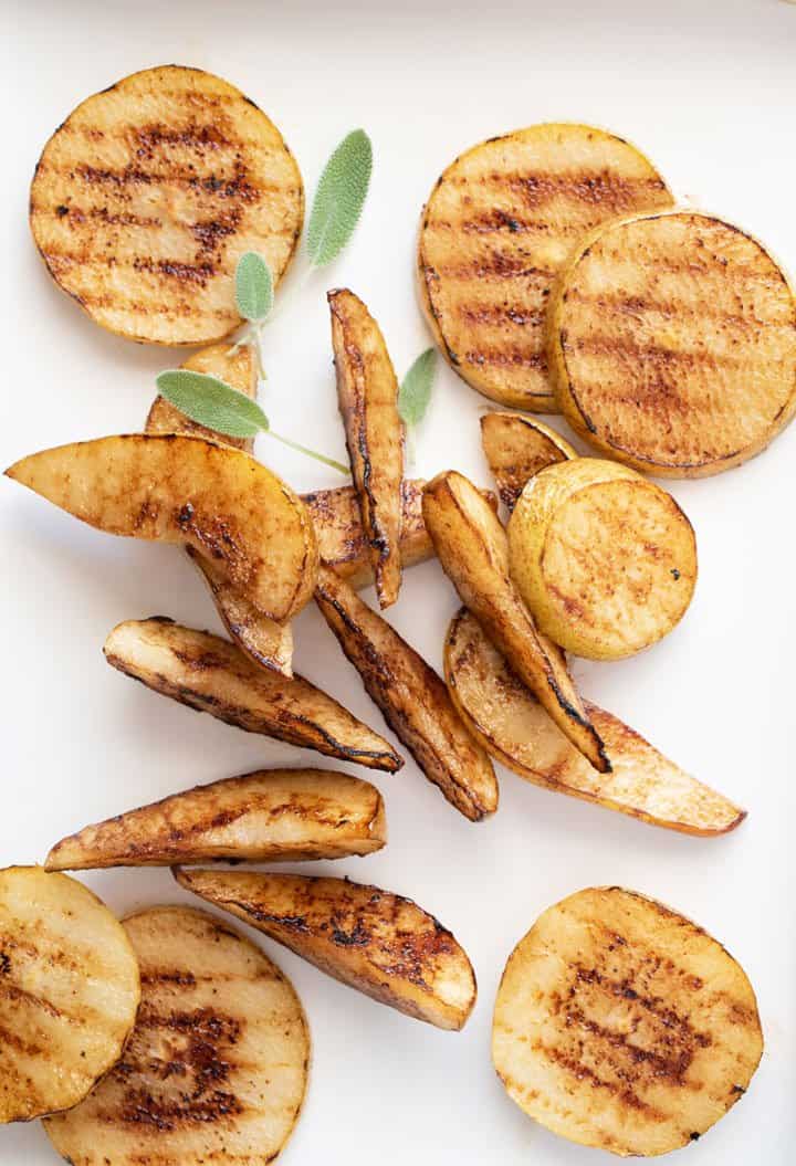 Grilled pear slices and wedges with small sage leaves. 