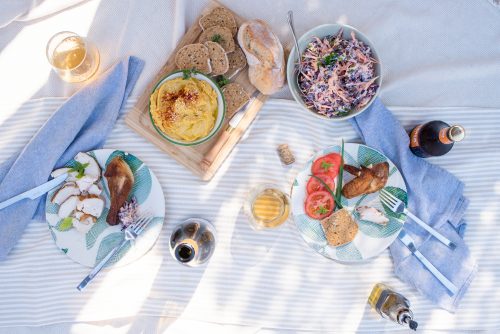 Summer picnic spread with chicken, hummus and coleslaw