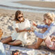 Attractive couple enjoying a picnic with friends on the beach.