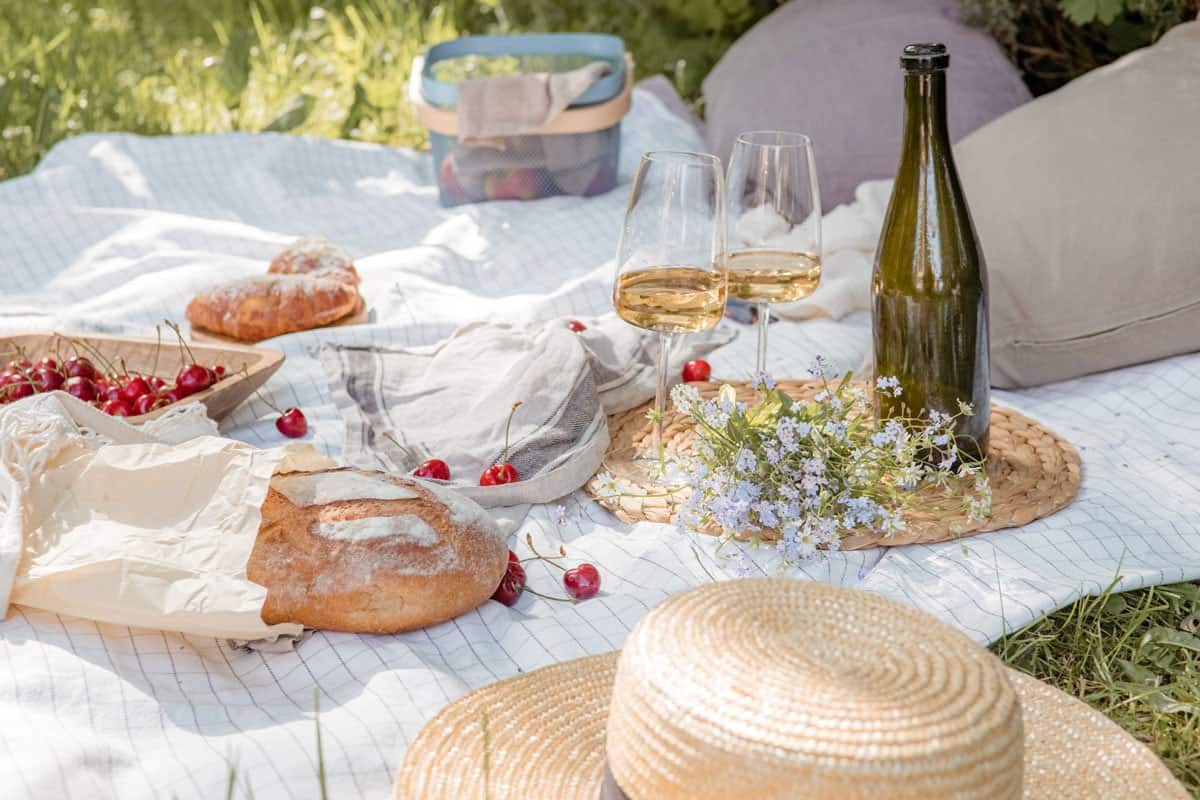 Picnic setting with spring flowers, bread, cherries and wine. 