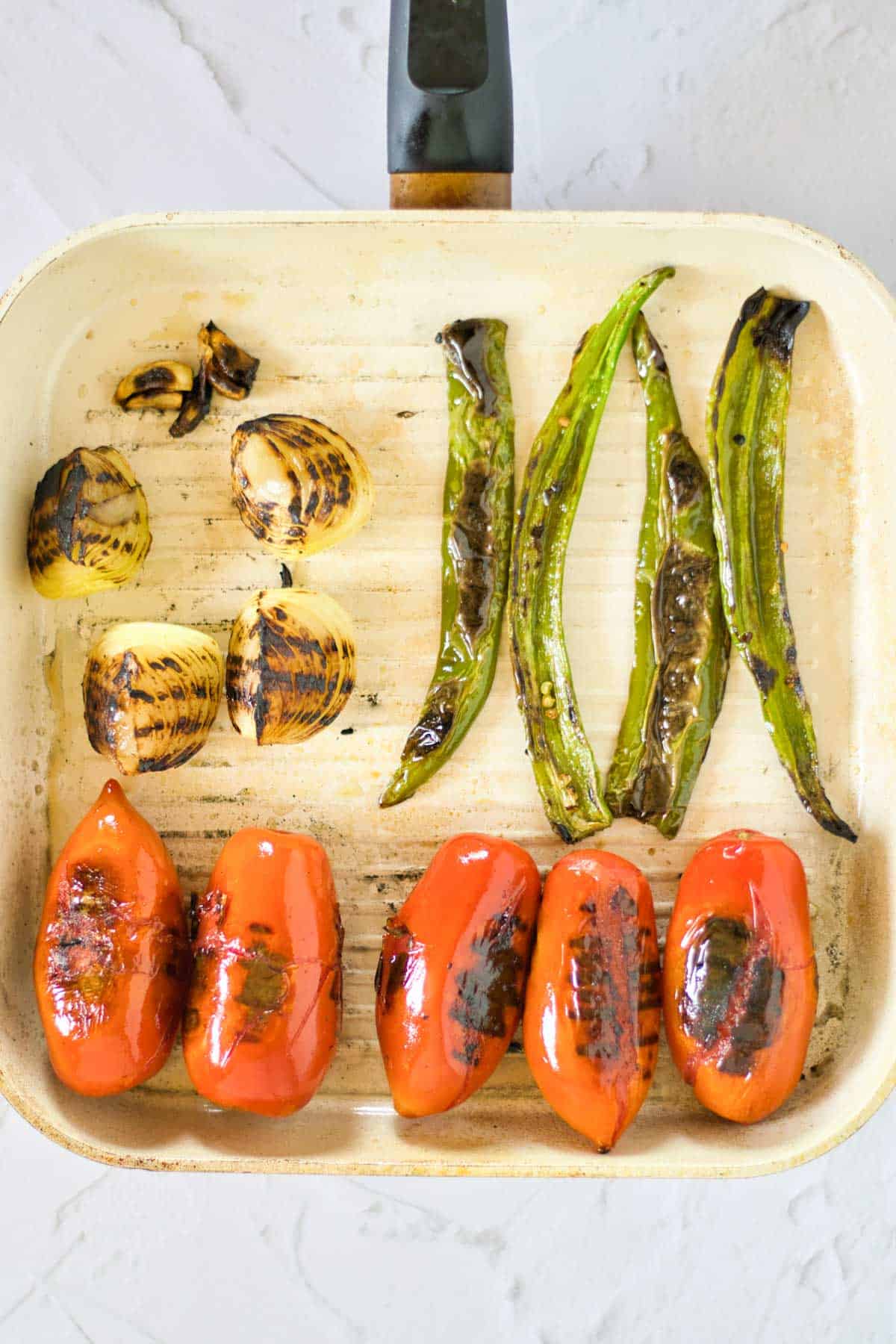 Grilled vegetables for salsa roja in a pan.