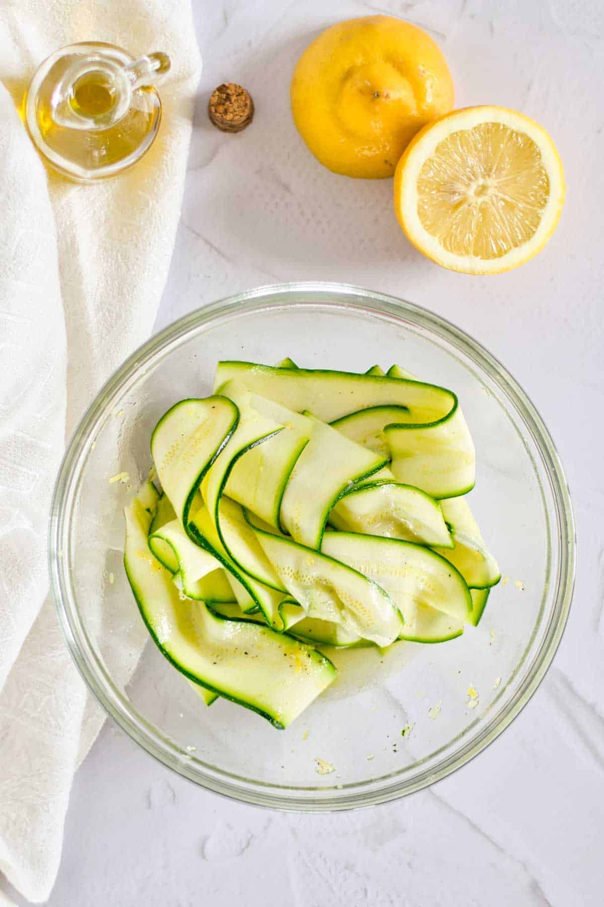 A glass bowl with zucchini ribbons.
