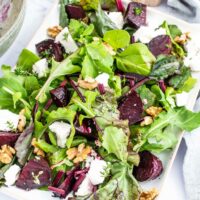 Colourful roasted beet salad with fresh greens, feta and walnuts.