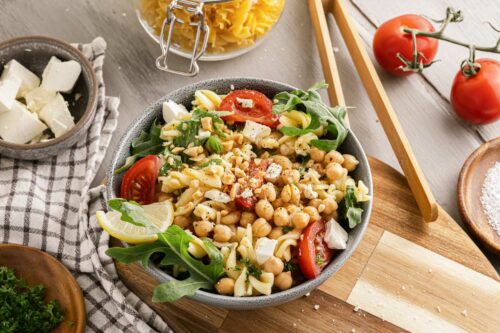 Chickpea Pasta Salad surrounded by fresh ingredients.