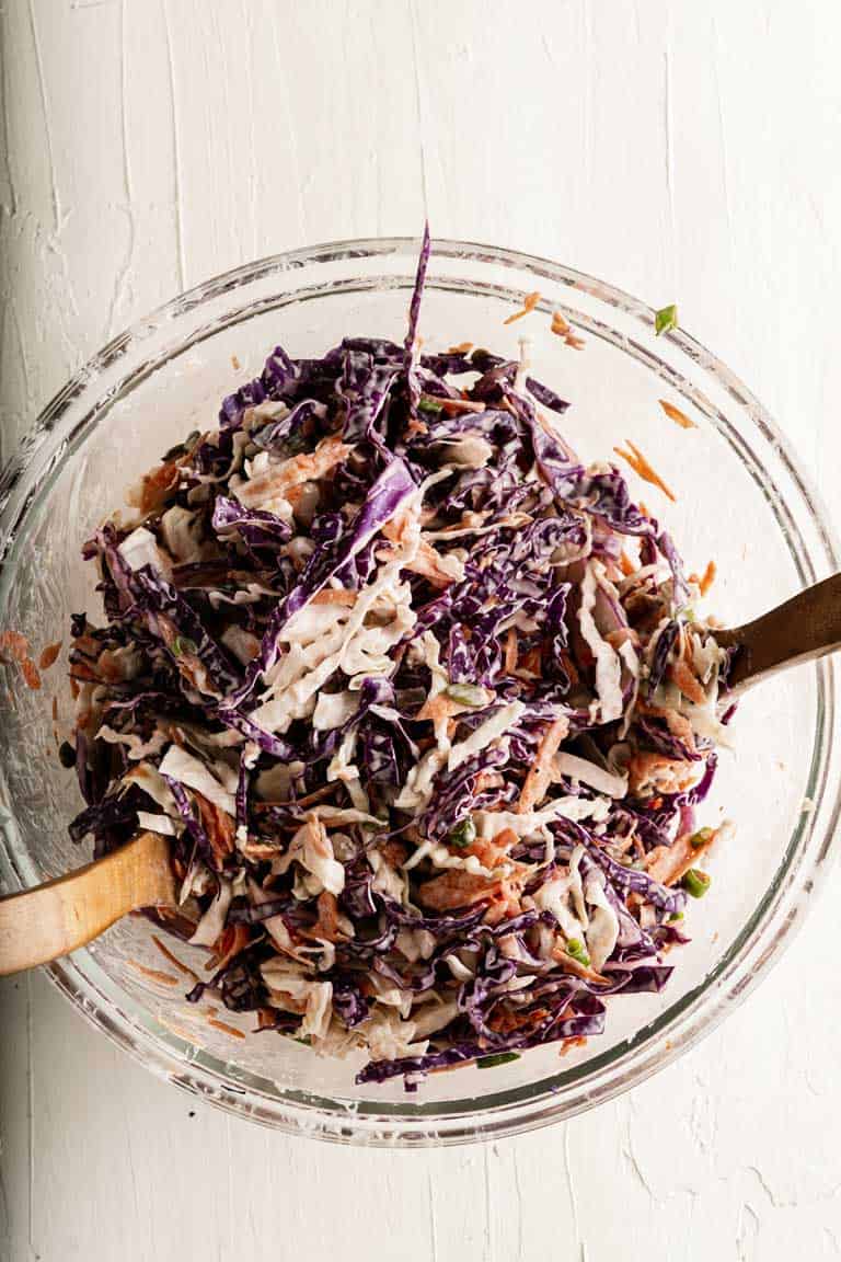 Bowl of coleslaw being mixed.
