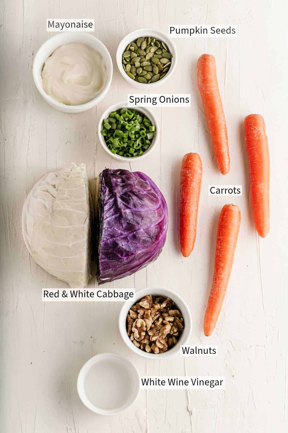 Ingredients for crunchy coleslaw on a white wooden table