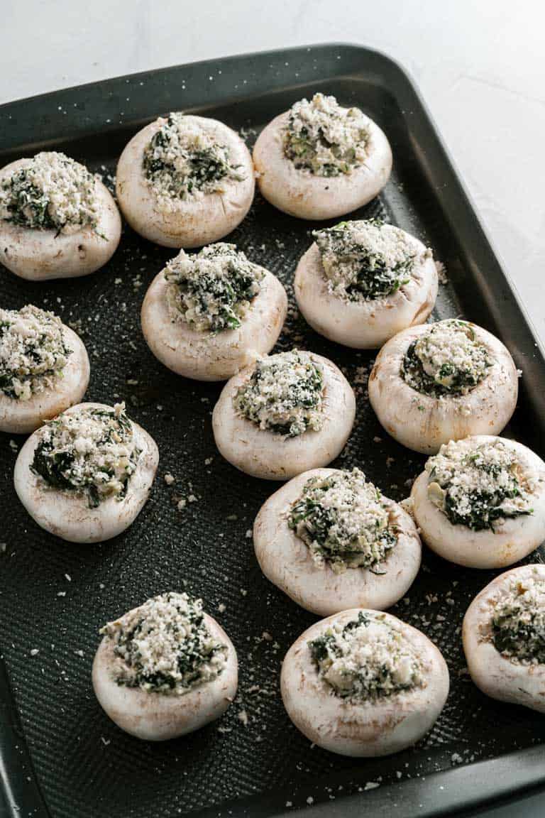 Tray of spinach stuffed mushrooms before baking.