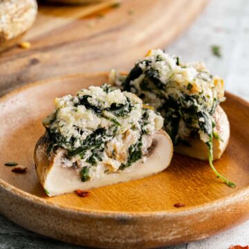 Stuffed mushrooms with spinach and cheese on a plate.