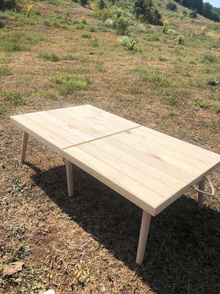 Foldable wooden picnic table set up outside on the grass. 