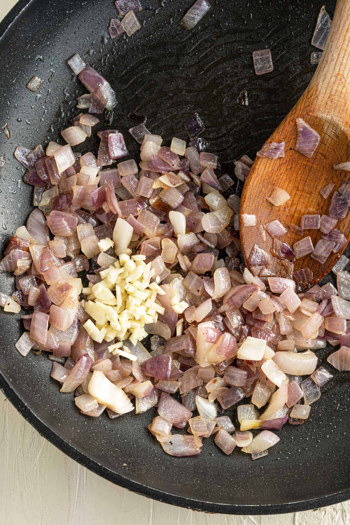 Onions and garlic sauteed in a pan.