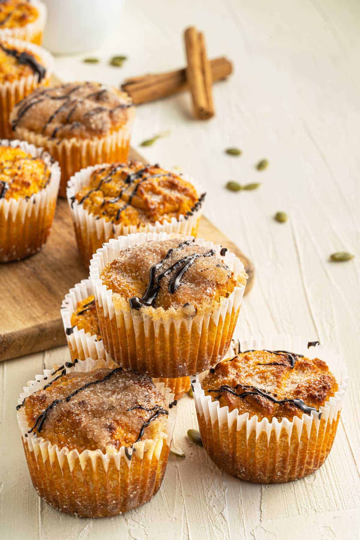 Low carb pumpkin muffins displayed on a serving board with pumpkin seeds scattered around. 
