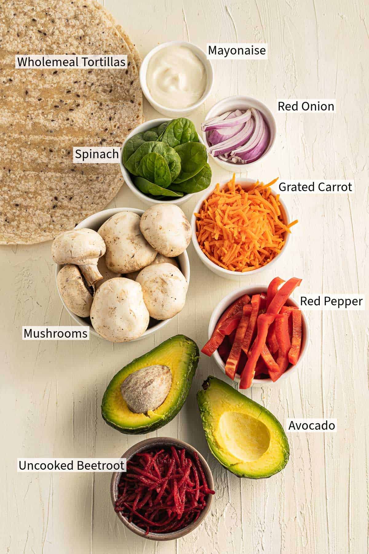 Ingredients for raw veggie wraps on a table.
