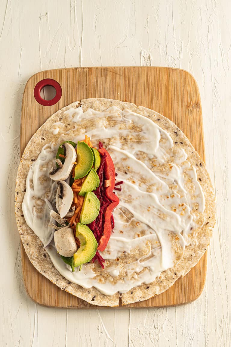 Tortilla wrap with mayonnaise and raw veggie fillings.