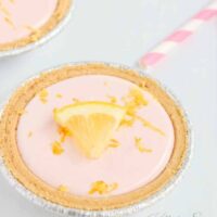 Pink lemonade mini pies with lemon wedge on top.