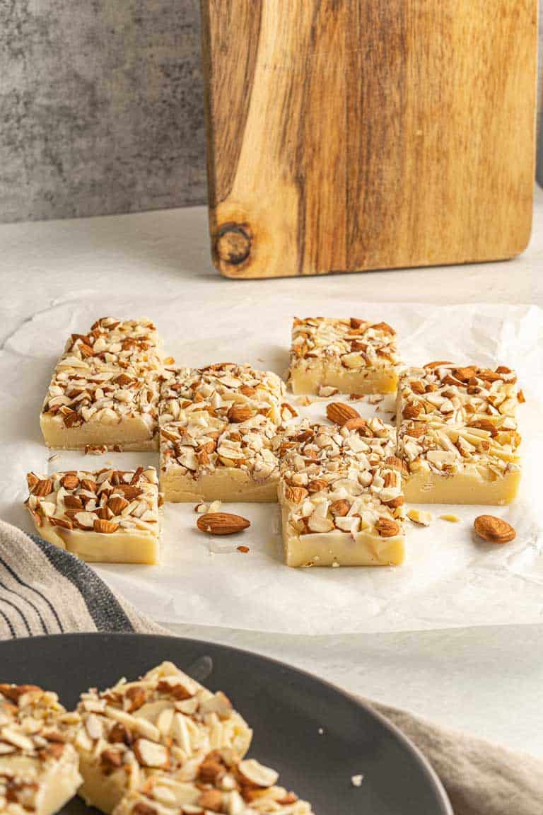 Squares of white chocolate fudge with almonds on top.