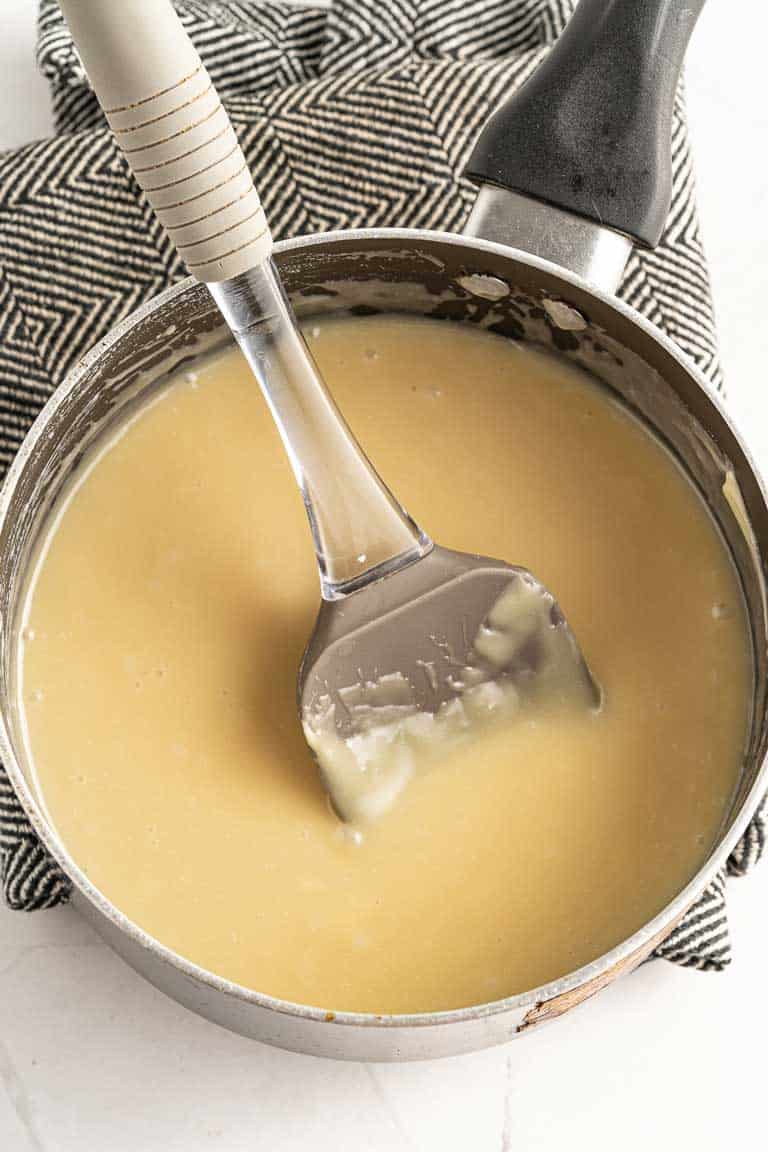 Mixing white chocolate fudge ingredients in a saucepan while they melt.