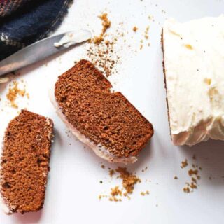 Slices of gingerbread loaf with cream cheese frosting.