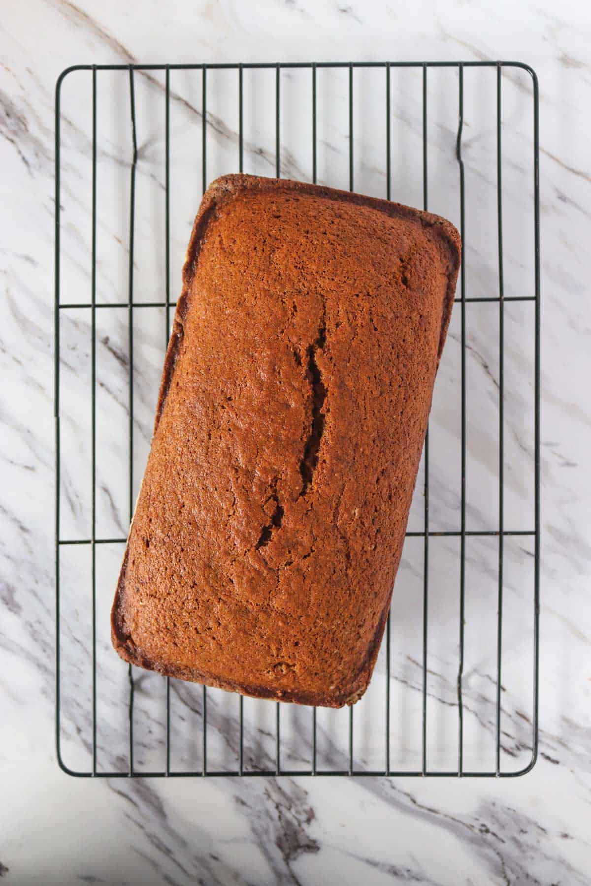 A gingerbread loaf on a cooling rack.