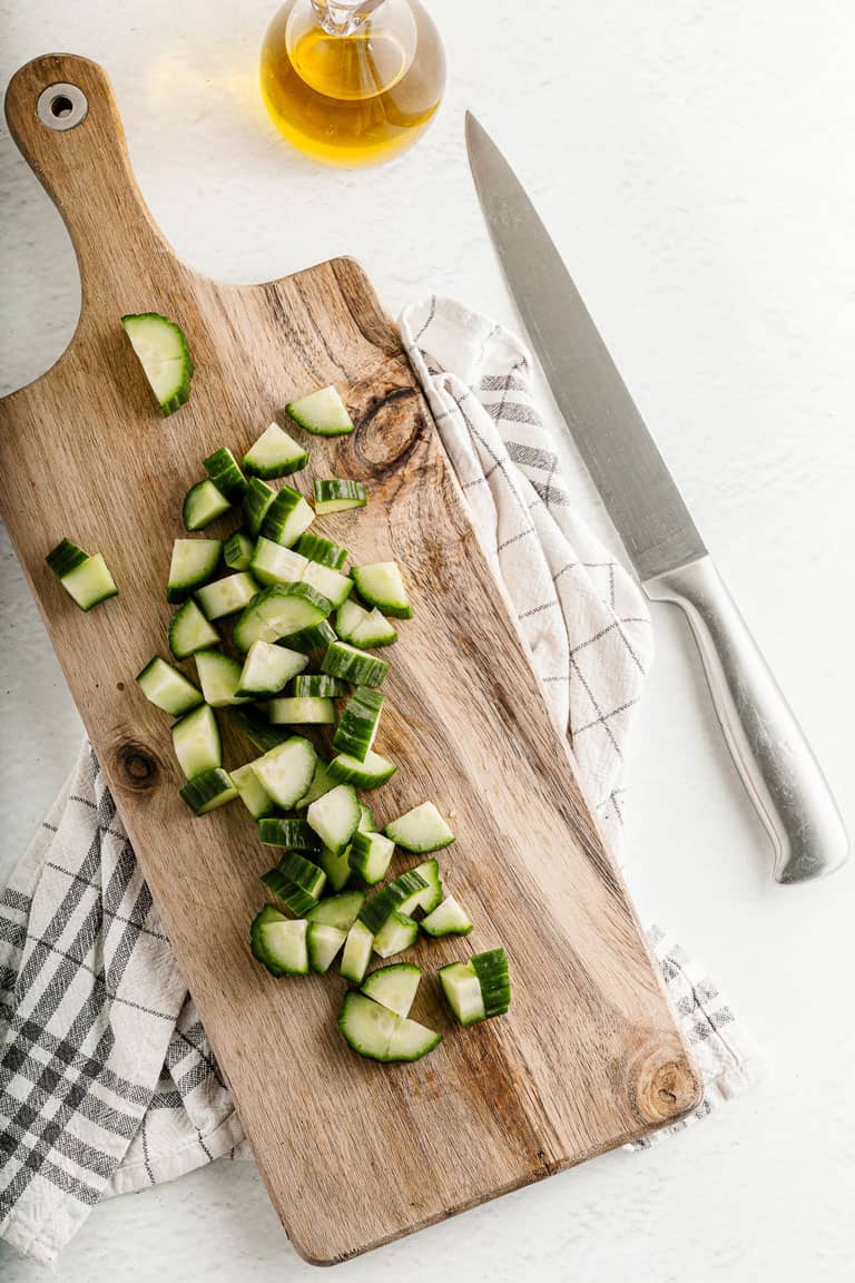 Chopped cucumber on a chopping board.
