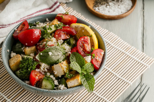 Bowl of salad with couscous and tofu.