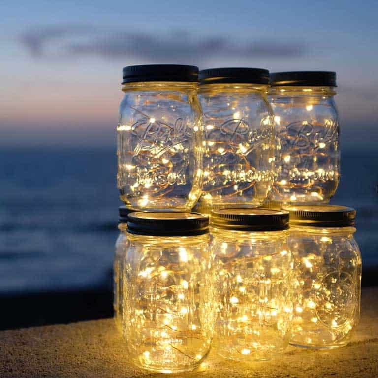 Six mason jars filled with string lights.