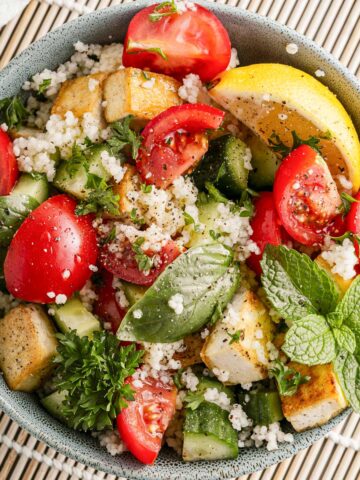 Bowl of salad with couscous and tofu.