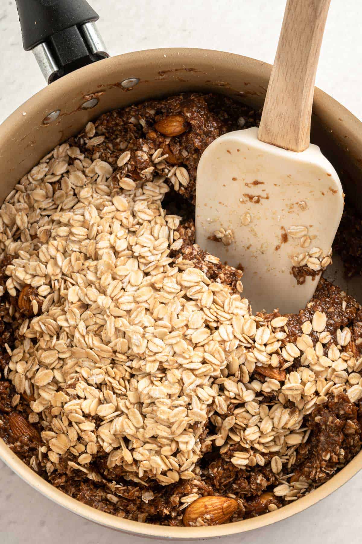 Adding oats to the chocolate granola bar mix.