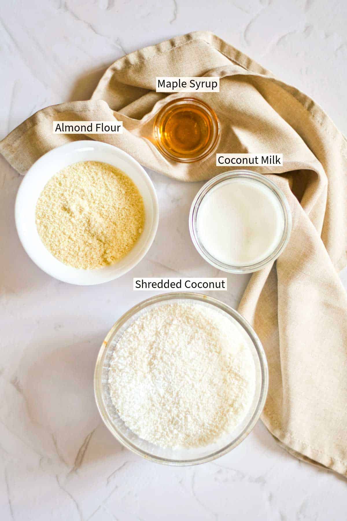 Ingredients for No-Bake Coconut Balls labelled on a table. 