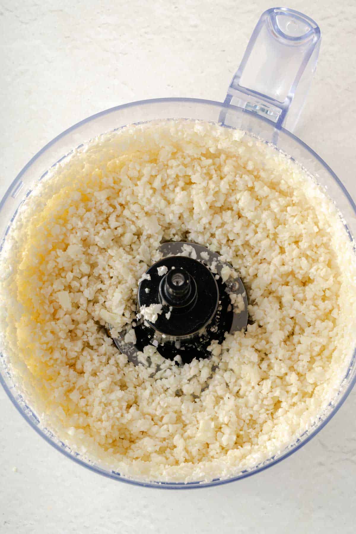 A food processor filled with cauliflower rice.