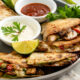 A plate of freshly cooked mushroom quesadillas with dipping sauces.