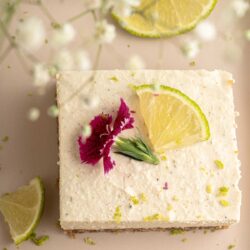 No bake Key lime pie bars with a lime and flower garnish.