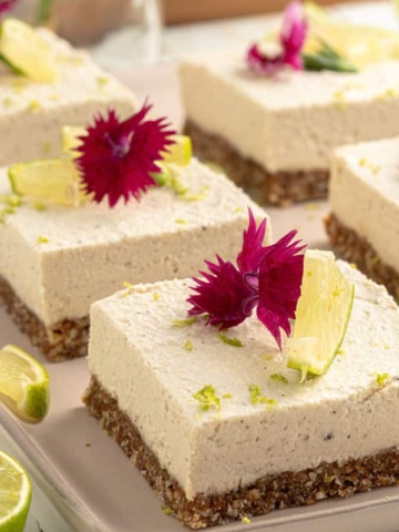 No bake Key lime pie bars on a tray garnished with pink flowers.