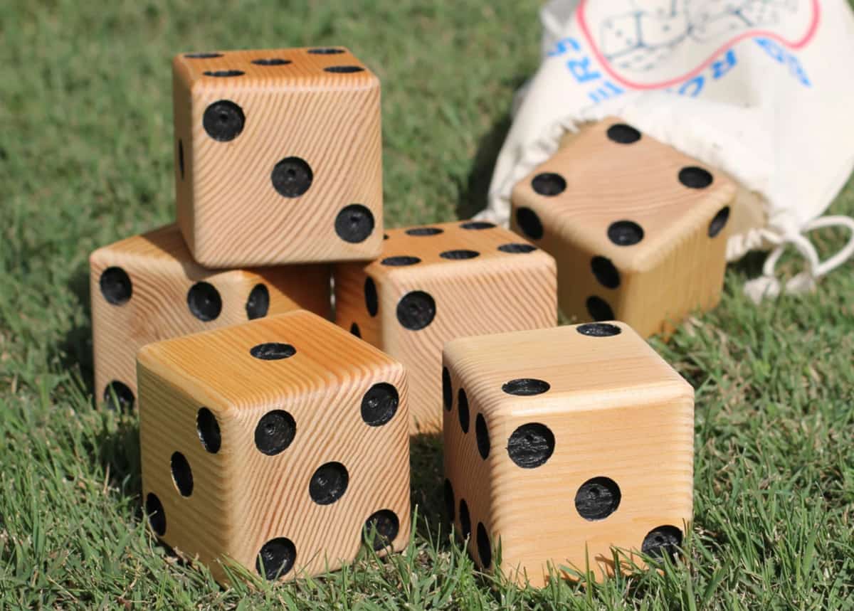 Set of wooden lawn dice on the grass. 