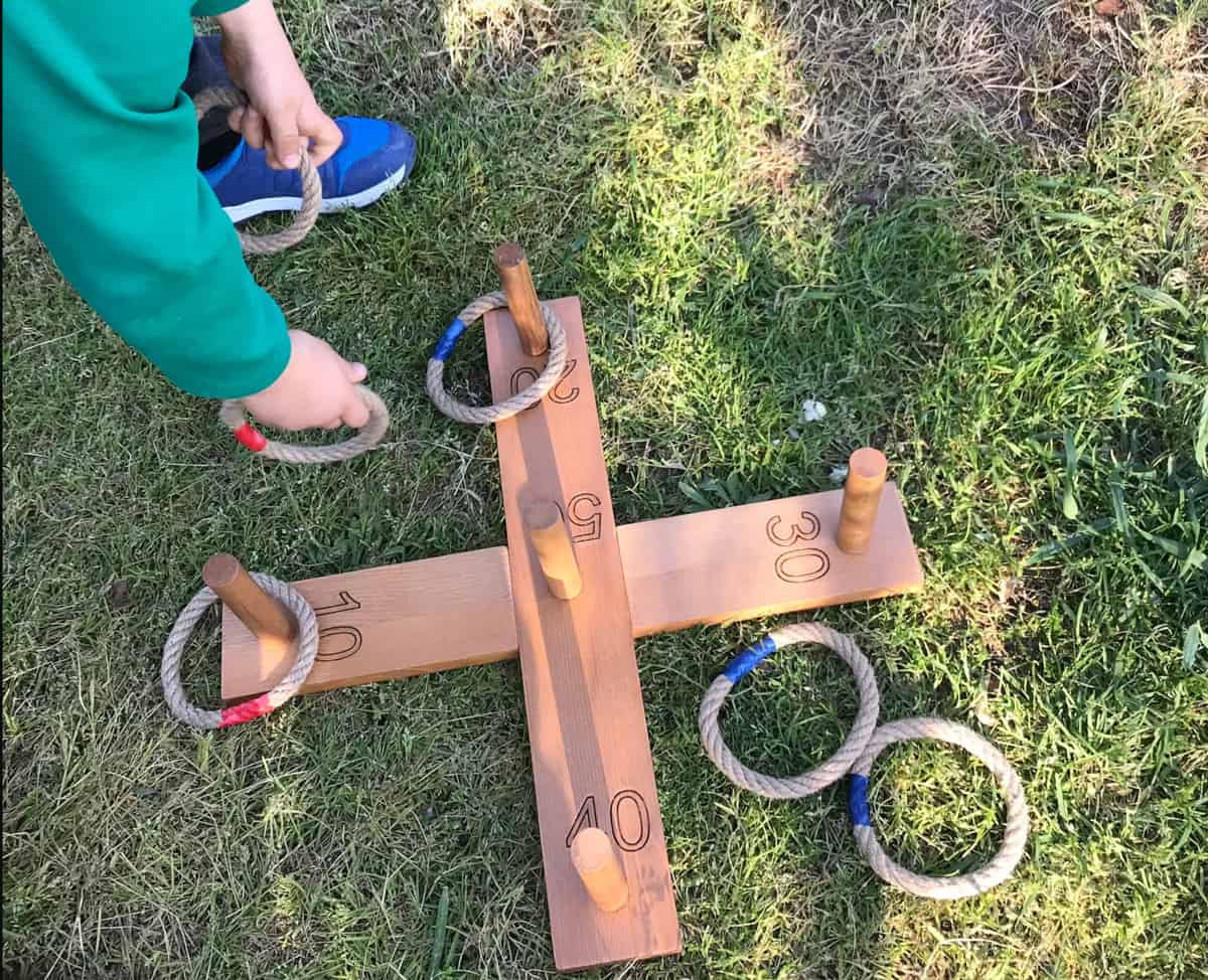 Wooden and rop ring toss game on the lawn. 